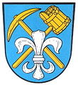 Gemeinde Förtschendorf In Blau schräg gekreuzt ein goldener Zweispitzpickel und ein goldener Schöpfkübel, belegt mit einer gesenkten silbernen heraldischen Lilie.[2]