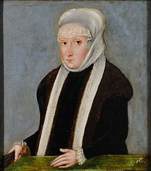 A woman in black wearing a long white scarf on her head and around her neck