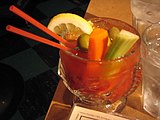 A Bloody Mary garnished with lemon, carrot, celery, and pitted manzanilla olives
