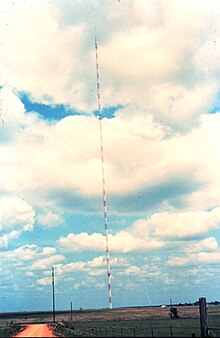 The transmission tower for KFOR-TV in Oklahoma City, in the middle of a field with a dirt access road in the foreground.