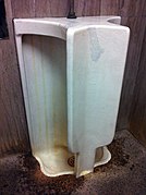 A double urinal. One person can urinate on each side.