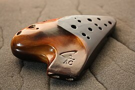 An Asian double chambered ocarina. The two blow holes in the mouthpiece are clearly visible, which makes it possible for the player to play an extended range of notes (17 in total, in this case from A4 to C6)
