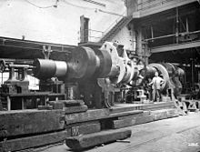 Finishing the ends of a crankshaft after building;[111] an improvised lathe for machining a large steam engine crankshaft, 1900[72] with a worm and wheel for turning the shaft in the centre. In the background on the far right is a screw cutting machine.[112]