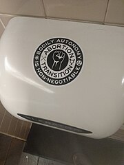 Sticker art expressing support of the pro-choice and transgender rights movements on a hand dryer in a public restroom in Portland, Oregon