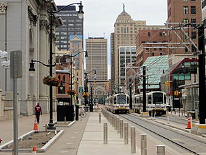Trains on a city street surrounded by tall buildings