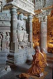 Buddhist monks praying in front of the Dagoba of Chaitya in Cave 26 of the Ajanta Caves.