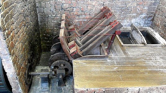 Model of a falling-stock machine, showing the set of hammers that drop in sequence to pound the cloth in the vats below.