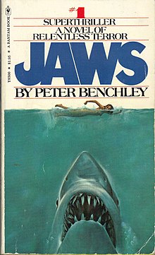 Painting of a shark head rising up on a naked swimmer. Atop the cover is "#1 Superthriller – A Novel of Relentless Horror", followed by the title and author, "Jaws by Peter Benchley".