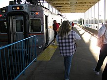 Passengers board a single-level train from a high-level platform