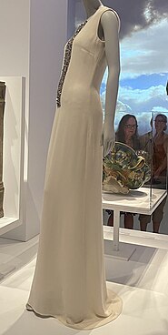 Floor-length sleeveless white dress with gold detail