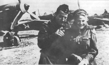 A man and a smiling woman in front of several planes