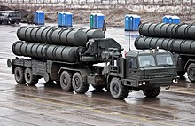 A large, wheeled military vehicle with four missile tubes on top.thumb