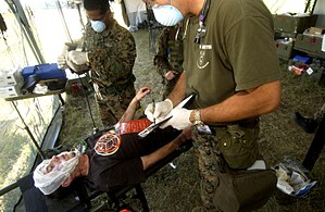 U.S. Navy medical technicians assess an injured civilian during a simulated man-made disaster during RESCUER/MEDCUER 05(RM 05). The annual exercise is designed to improve interoperability among the 17 participating countries by conducting crisis response, disaster relief, consequence management, and humanitarian assistance operations. (September 19, 2005)