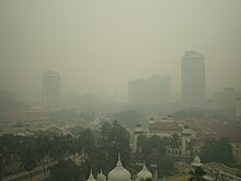 Smog engulfing a city skyline.