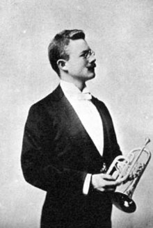 Man wearing formal suit, holding cornet