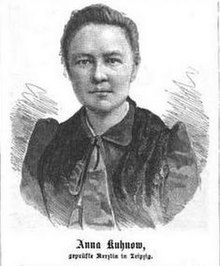 Anna Marie Kuhnow ist auf einer Zeichnung mit vermutlich schwarzer Kohle dargestellt. Sie hat eine dunkle Bluse an und trägt eine lange lockere Krawatte. Ihr Haar ist zurückgebunden.