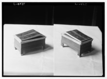 Two, side-by-side monochromatic images of showing three-quarters view of an ornate wooden box inscribed with an Egyptian hieroglyph cartouche.