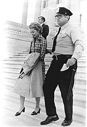 Woman arrested by male police officer on steps of United States Capitol.