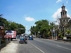 Agoo town center along the National Highway with the steeple of Basilica Minore of Our Lady of Charity on the right