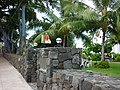 Stone wall and gate of Hulihe'e Palace with musicians in the yard. (10/2012)