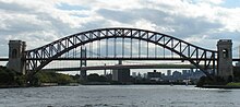 The Hell Gate Bridge's main span in front of the Robert F. Kennedy Bridge's suspension span, as seen from Hell Gate