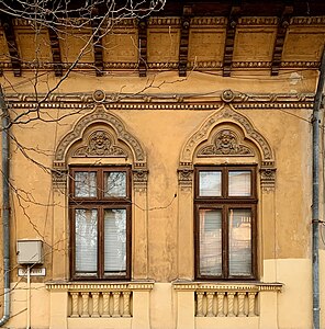 Romanian Revival windows with seraph mascarons at the top, on the facade of Strada Polonă no. 13, Bucharest, unknown architect, c.1900