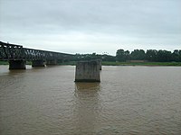 The pillar stubs of the Yalu River Broken Bridge between Dandong and Sinuiju, which was established in 1911 and destroyed during the Korean War. The bridge to the left is the Sino-Korean Friendship Bridge, which opened to traffic in 1943 and also fell to destruction by US aerial attacks during the war but was successfully repaired after 1953 (direction of photo looking south into North Korea).