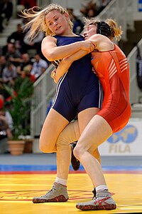 Photograph of two female wrestlers grappling each other