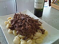 Unsauced shredded beef atop gnocchi