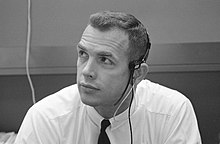 A man in a dress shirt and tie wearing a headset