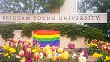 An LGBT flag displayed at the main BYU campus sign