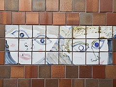 Tiles with blue abstract portraits on a brown tile wall