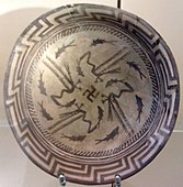 Samarra plate, with an abstract rim, a circle of eight fish, and four birds catching four fish that swim towards a central swastika; circa 4000 BC; painted ceramic; diameter: 27.7 cm; Vorderasiatisches Museum Berlin