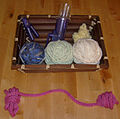 A hobbyist spool knitting machine operates on a crank.