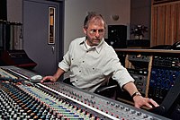 Record producer Elliot Scheiner, seated while using an audio mixing console.