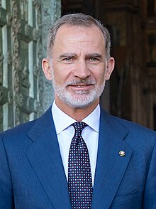 Felipe is pale-eyed, with a white beard, and wears a suit and teal-coloured tie.