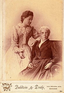 Cabinet B&W photograph of Jones sitting, with her granddaughter standing next to her