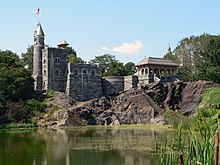 Belvedere Castle with a pond in front and an American flag flying over the tower