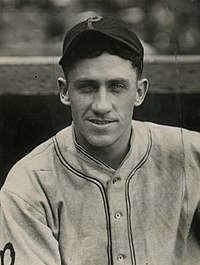 A man in a light baseball uniform and a dark cap with a lighter "P" on the center
