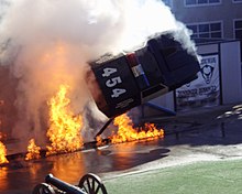 An exploding police car elevated by a cantilever during a performance of Police Academy Stunt Show.