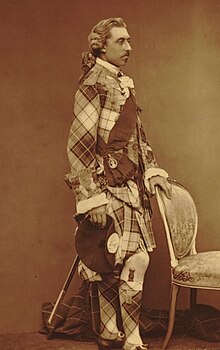 Prince Arthur with his hand on a chair, and dressed in an elaborate tartan costume
