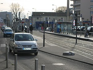 Double-track railway line in street with shelters on side platforms