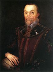 Man with a high forehead and short pointed beard, in dark clothing which incorporates a shining leather or metallic collar. His right hand is resting on a globe of the world.