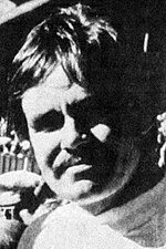 Close-up photo portrait of Cormac McCarthy with a mustache and medium-length hair