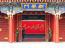 Photo of Xinhua gate (Xinhuamen/新华们) entrance in 2003 showing the slogan "为人民服务" in handwritten script