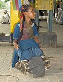 K29. A girl playing a drum at the Gurgaon railway station, Haryana