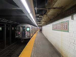 A rear view of a subway train leaving an underground station
