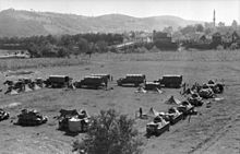 a black and white photograph of German armoured vehicles and tents in a square formation in open country