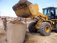 Iraqi Army engineers fill a section of four-foot HESCO MIL with a wheel loader.