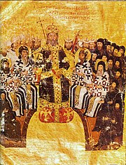 Sitting elderly man in black and gold robes, wearing a golden crown and holding scepter in the center. Behind and around him, arranged in a semicircle, are seated bearded men, some in white and others in black dress. Bearded heads of other men with tubular and triangular hats are visible behind them.
